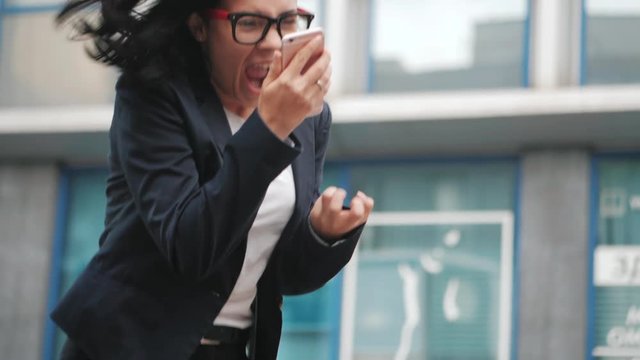Businesswoman screaming down her mobile phone in slow motion. Having nervous breakdown at work, screaming in anger, stress management, mental distress problems, losing temper, reaction on failure