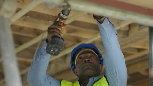  Construction worker on a building site checking roof struts & wiring