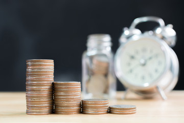 Coin stack step up increase save money with blurred clock and jar background, Finance and investment concept