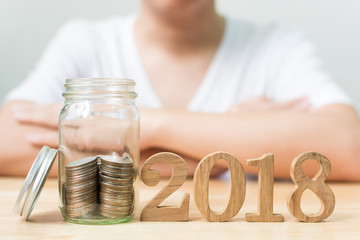Coin stack in jar with wood number 2018 year, Save money and investment concept