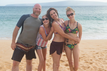 Happy family of four at a tropical beach vacation