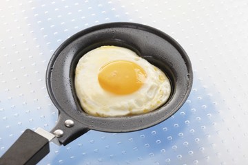 Fried egg, heart-shaped, in a small pan