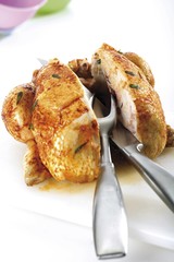 Roasted chicken cut in half, carving set