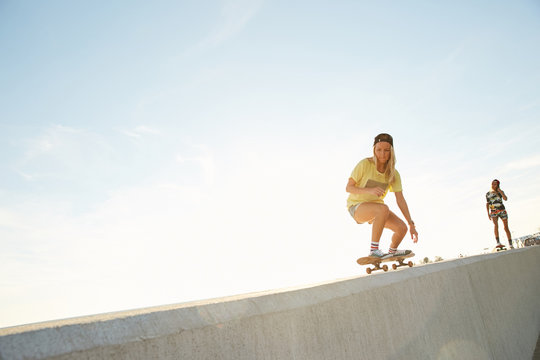 Girls skateboarding on a bank of the sea in the sunset in Sochi