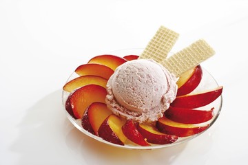 Vanilla ice cream with plum slices and wafers