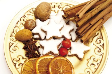 Christmas plate: cinnamon sticks, star-shaped cinnamon cookies, star anise, dried orange slices, rose hips and nuts