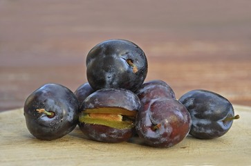 Fresh plums on a wooden board