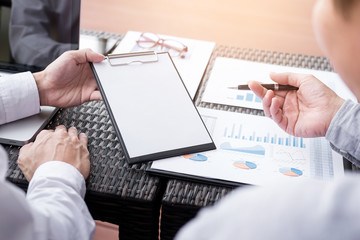 Business people discuss together about there work by graph document and setting in outdoor for planning financial strategy.
