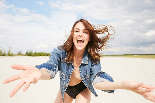 A model topless with jeans jacket in happy "hey" emotion on the beach