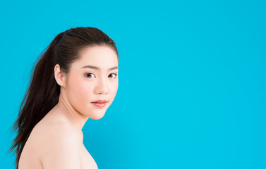 Fototapeta premium Young Asian woman with happy smile isolated on blue background.