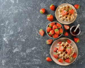 Traditional waffles with maple syrup and strawberries