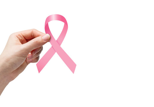 Woman hand holding pink ribbon for breast cancer awareness on white background