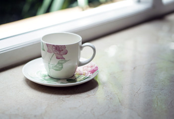 a coffee tea cup by the window with outdoor view
