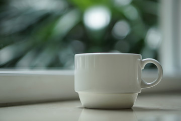 a coffee tea cup by the window with outdoor view