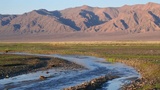 Mongolian natural landscape with river Oshiin-Gol and mountains on background. Khovd province of Mongolia