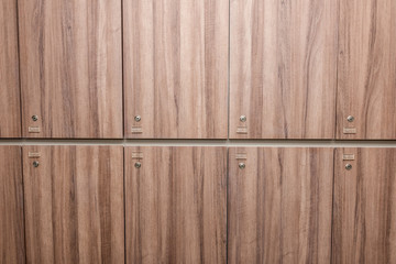 Brown wooden locker with key holes and number background.