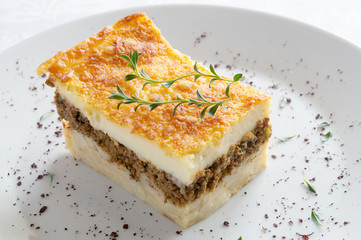 pastitsio piece decorated with thyme and sumac