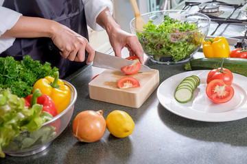 Young Woman Cooking in the kitchen. Healthy Food.