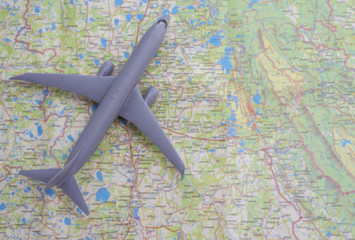 Fototapeta na wymiar A miniature of a passenger aircraft flying on a map. A conceptual image for tourism and travel. place for text