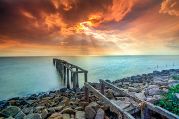 A long Exposure Picture Of abandoned old jetty with  burning sunset as background