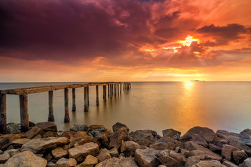 A long Exposure Picture Of abandoned old jetty with  burning sunset as background