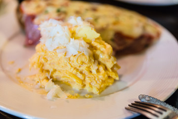 Scramble egg served with sliced baguette topping with bacon and cheese at the restaurant in Chiang Mai, Thailand.