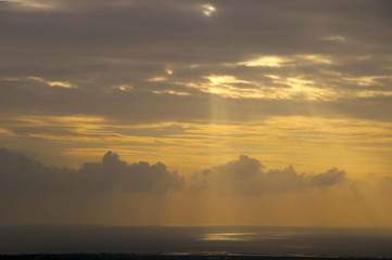 Sun rays falling on sea water with   orange and  gray  background