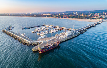Sopot-resort in Polen. Houten pier (molo) met jachthaven, jachten, toeristisch piratenschip, strand en vakantie-infrastructuur. Luchtfoto bij zonsopgang