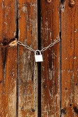 Closeup shot of the padlock on the old wooden gates