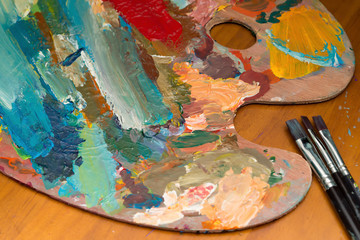 Fototapeta premium palette and paint brushes on wood table