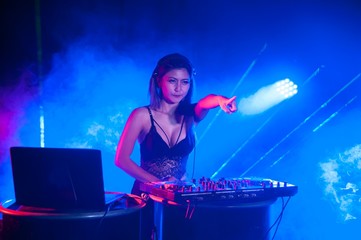 Pretty Asian female woman DJ playing music for dance.