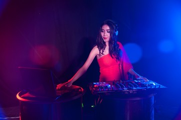 Pretty Asian female woman DJ playing music for dance.