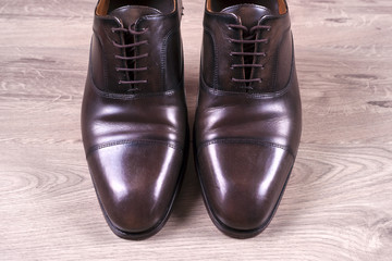 Male fashion with shoes on wooden background.