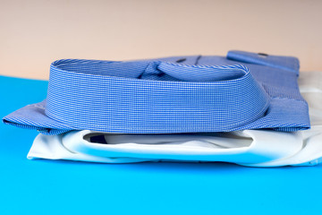 Stack of blue and white shirt closeup on a light background.