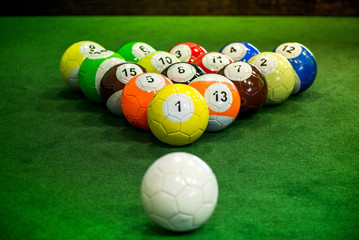 Shot of foot pool balls standing on green table. Foot Pool is the hybrid combination of pool and soccer. Big billiard balls. 