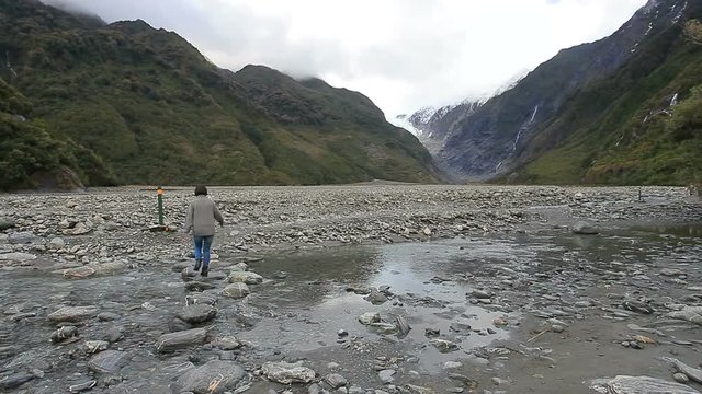 woman tourist walking in trail of fox glacier new zealand
