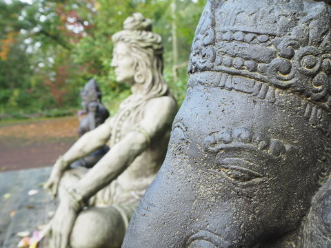 Shiva und Ganesha Statue im Profil aus Stein sitzend auf Holzplattforn