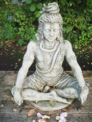 Shiva Statue aus Stein sitzend auf Holzplattforn