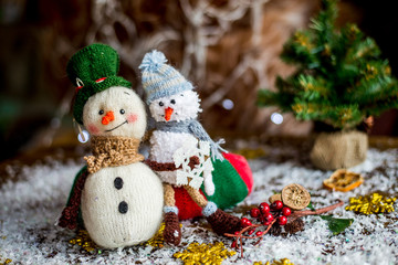Handmade yarn snowman holding gifts in a sock, boot.