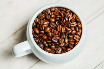 
Cup of coffee full of coffee beans. Close-up

