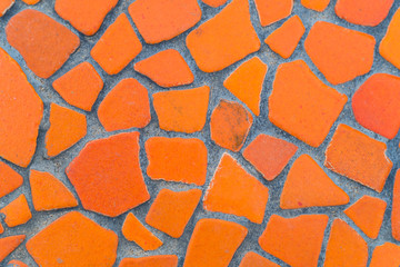 Texture of orange tile floor on cement walkway. The front walkway is built of inexpensive cement in the garden. Close up orange rock surface, ideas for house and garden design. - Background abstract.