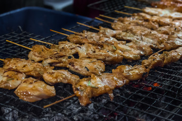 Kai yang - Thai style grilled chicken street food on the night market in Chumphon and Bangkok. Originating from Lao people in Laos and Isan