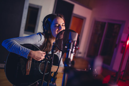 Female vocal artist singing in a recording studio