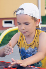 Young schoolboy holding popular fidget spinner toy - close up portrait. Happy smiling child playing with Spinner.