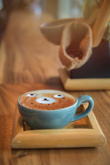 latte art coffee cup on wood table in coffee shop.