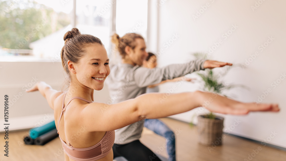 Wall mural Woman practicing yoga at gym class