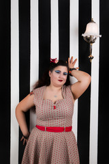 Pinup girl posing on a stripes backdrop