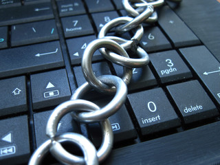 Chain with lock on computer keyboard. It means laptop banned or internet banned. Symbol of computer addiction, games, social networks and so on