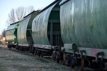 Fototapeta na wymiar City junction railway yard on which sorting of freight railway trains takes place. Train wagons in row on the rails at railway station. Freight train. Cargo waiting to be exported world wide by ship