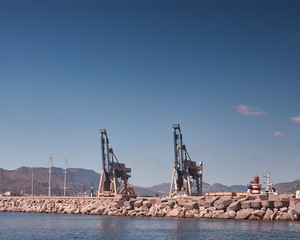 Fototapeta na wymiar Harbor crane, mountains in background